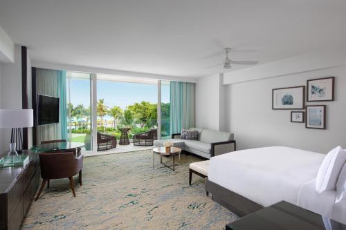 プロビデンシャレスにあるThe Ritz-Carlton, Turks & Caicosのベッドとリビングルームが備わるホテルルームです。