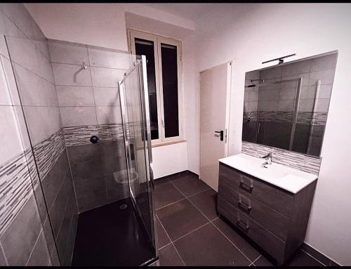 uma casa de banho com um chuveiro, um lavatório e um espelho. em Melting Pot Rome em Roma