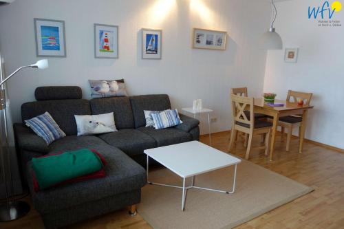 ボルクムにあるFerienhaus Seeblick Ferienwohnung 53のソファとテーブルのあるリビングルーム