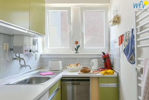 una cocina con fregadero y encimera en Dünenschlösschen Ferienwohnung 10, en Wangerooge