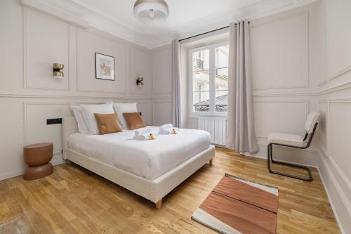 パリにあるPoetic Stay - Saint Lazareの白いベッドルーム(ベッド1台、椅子付)