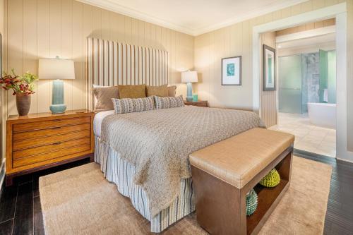 a bedroom with a large bed and a bathroom at The Lodge at Kukuiula - CoralTree Residence Collection in Koloa