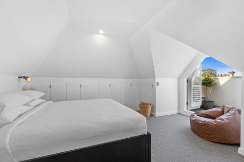 een slaapkamer met een groot bed en een stoel bij Elegant & Stylish Home by the Botanical Gardens in Melbourne