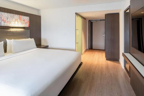 a bedroom with a large white bed and a television at Aloft Sunnyvale in Sunnyvale