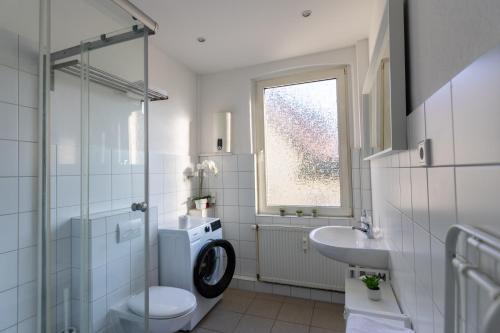 ein Bad mit einem WC, einem Waschbecken und einer Waschmaschine in der Unterkunft CARICASA: Bielefeld Mitte in Bielefeld