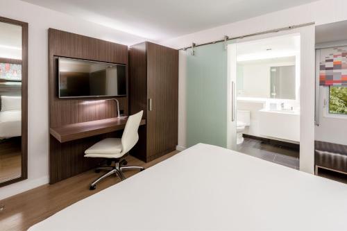 a bedroom with a bed and a desk and a tv at Aloft Sunnyvale in Sunnyvale