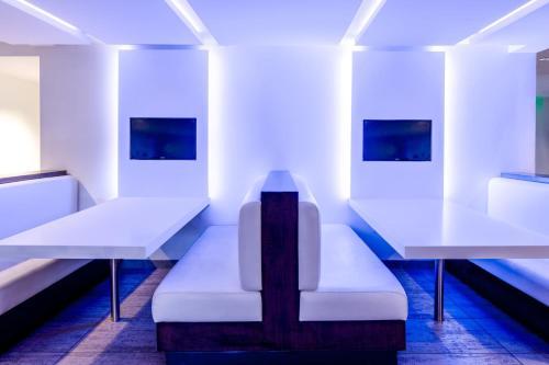 a room with two tables and a white bench at Aloft Sunnyvale in Sunnyvale