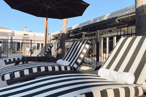 three lounge chairs with an umbrella on a patio at Four Points by Sheraton San Rafael Marin County in San Rafael