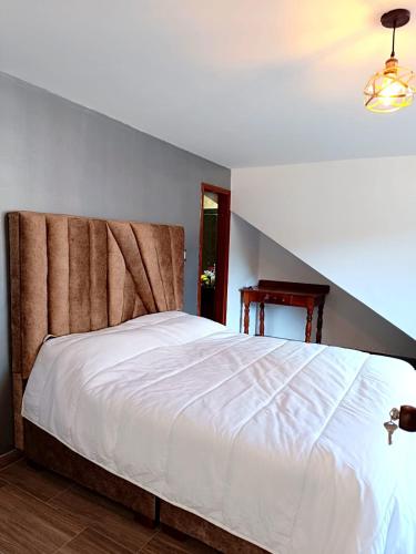 a bedroom with a large white bed in a room at LA PAZ! Espacios verdes y zona BBQ in Sogamoso