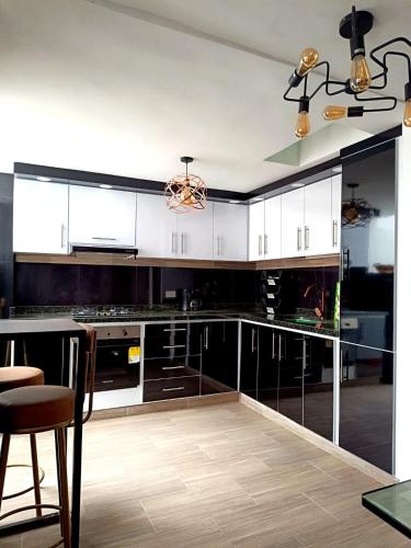 a kitchen with black and white cabinets and a table at LA PAZ! Espacios verdes y zona BBQ in Sogamoso
