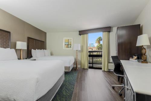 a hotel room with two beds and a balcony at Four Points by Sheraton San Diego Downtown Little Italy in San Diego