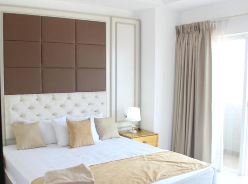 a bedroom with a large bed and a window at Airport Luxury Ocean Condos in Negombo