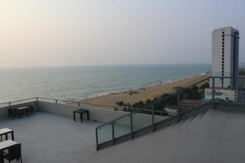 a balcony with a view of a beach and a building at Airport Luxury Ocean Condos in Negombo