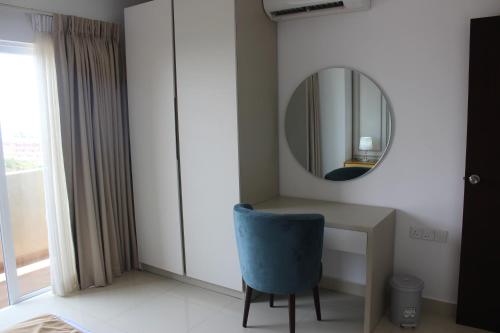 a room with a desk with a mirror and a blue chair at Airport Luxury Ocean Condos in Negombo