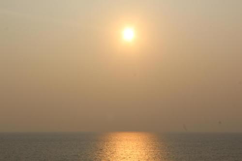 a sun in the sky over the ocean at Airport Luxury Ocean Condos in Negombo