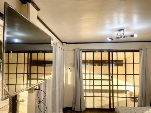 Cette chambre dispose d'une fenêtre et d'une porte avec des rideaux. dans l'établissement Maria Kulafu Studio Deluxe, à Masbate
