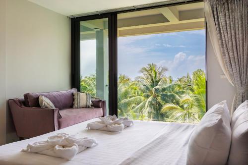ein Schlafzimmer mit einem Bett und einem großen Glasfenster in der Unterkunft 5br Luxury Villa prime location Koh Phangan in Ko Phangan