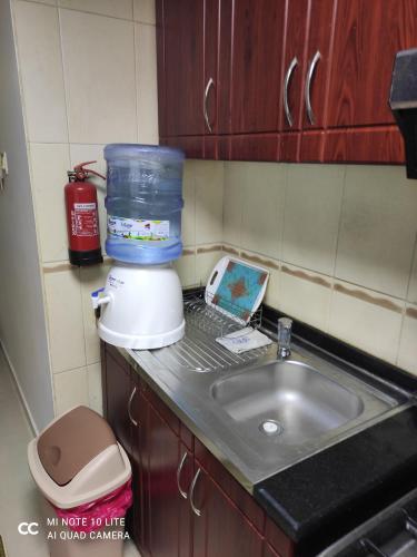 um balcão de cozinha com uma batedeira e um lavatório em El massa Quit apartment em Sharjah