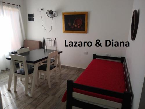 a dining room with a table and chairs and a red rug at Lázaro & Diana in San Clemente del Tuyú