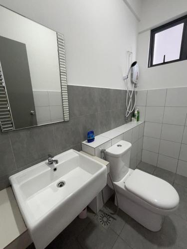 a bathroom with a sink and a toilet and a mirror at Happy House in Sandakan