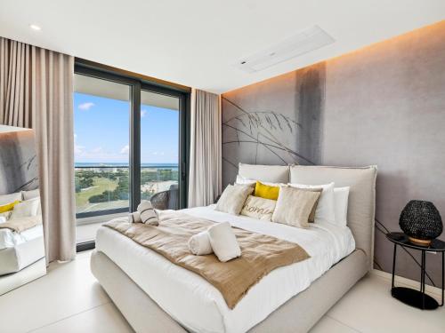 a bedroom with a large bed with a large window at Fourteen at Mullet Bay in Cupecoy