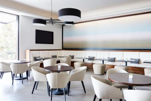 a restaurant with tables and chairs and a chalkboard at AC Hotel by Marriott Tampa Airport in Tampa
