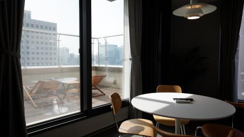 Una mesa y sillas en una habitación con una ventana grande. en Wecostay Namsan, en Seúl