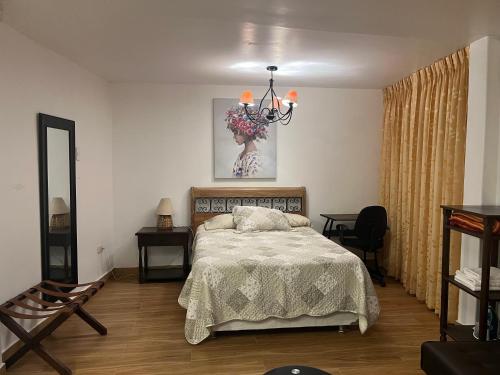 um quarto com uma cama e um lustre em Mini departamentos Miramar em Cajamarca