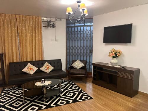 a living room with a couch and a tv at Mini departamentos Miramar in Cajamarca