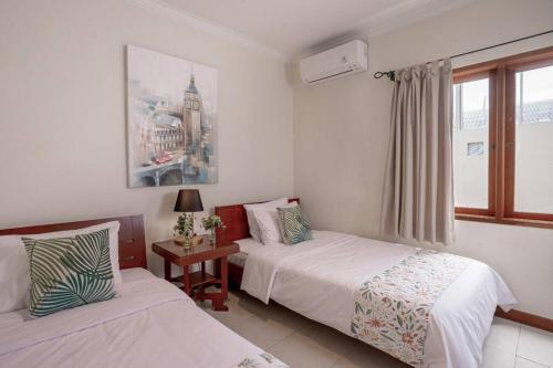 ein Hotelzimmer mit 2 Betten und einem Fenster in der Unterkunft Pasteur Beautiful Luxury Home in Bandung