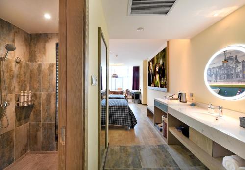 a bathroom with a bed and a sink and a mirror at Mehood Theater Hotel, Zhonglou Metro Station Huimin Street in Xi'an