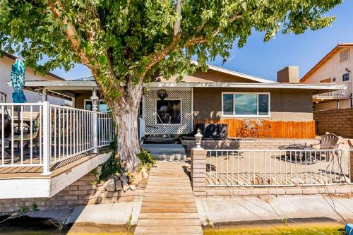 a house with a white fence and a tree at Lake Life Home in Victorville