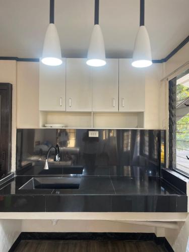 a kitchen with a black counter top and a sink at Maria Kulafu Studio Deluxe in Masbate