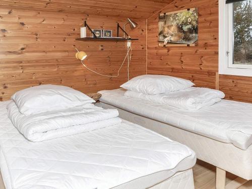 2 Betten in einem Zimmer mit Holzwänden in der Unterkunft Holiday home Løgstør IX in Løgstør