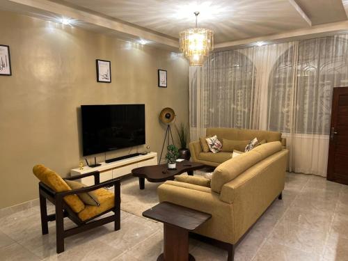 a living room with a couch and a television at Résidence Maronne in Porto-Novo