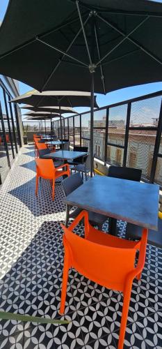 a group of tables and chairs with an umbrella at ALT URBANA in León