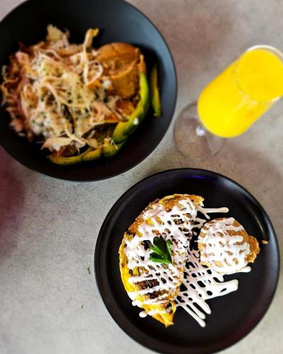 two black plates of food and a glass of orange juice at ALT URBANA in León