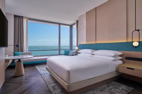 a bedroom with a large white bed and a large window at Penang Marriott Hotel in George Town