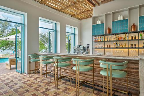 a bar with green stools in a room with a pool at Penang Marriott Hotel in George Town