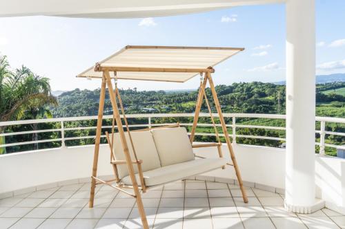 a swing on a balcony with a view at Location T2 Chic ducos proche de l'aéroport in Ducos