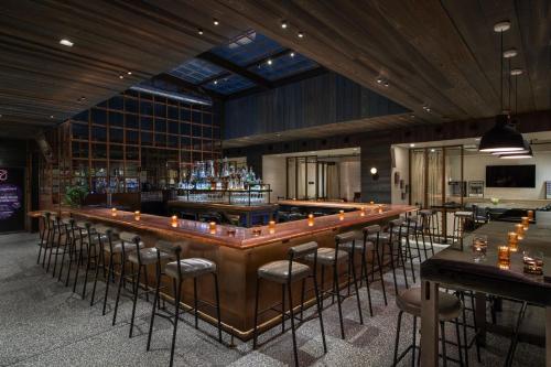 a bar with a bunch of stools in a room at MOXY NYC Times Square in New York