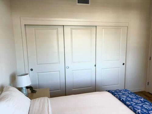 a bedroom with two white closet doors and a bed at Urban SLO Living- 1 mile from downtown in San Luis Obispo