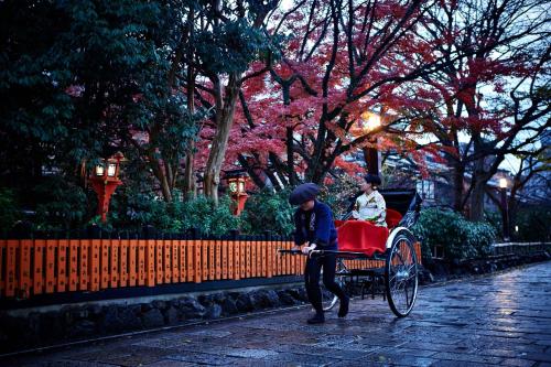 a young boy pushing a child in a rickshaw at The Ritz-Carlton Kyoto in Kyoto