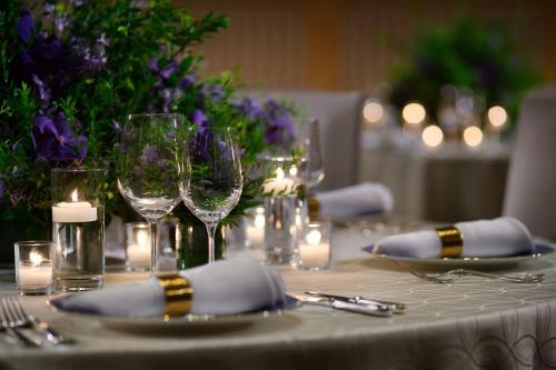 a table with wine glasses and candles and purple flowers at The Ritz-Carlton Kyoto in Kyoto