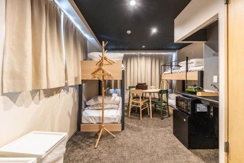 a dorm room with bunk beds and a table at HOTEL HARE BARE 3min walk from Kiba Station in Tokyo