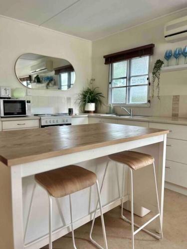 a kitchen with a large counter with two stools at Beach Shack by the Sea Innes Park in Pemberton