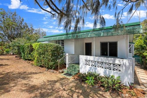 a white house with a green roof at Beach Shack by the Sea Innes Park in Pemberton