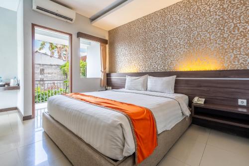 a bedroom with a large bed with an orange blanket at Casa Dasa Legian in Seminyak