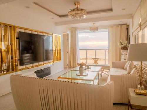 a living room with a large television and a couch at Beachfront Seaview Apartment in Male City