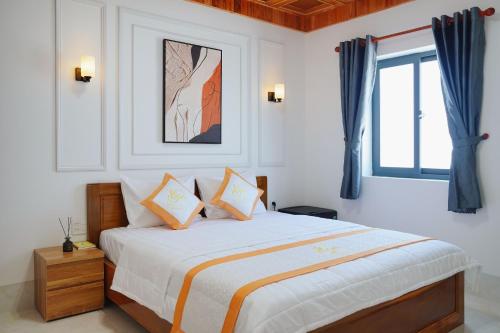a bedroom with a large bed with blue curtains at BÌNH MINH HOTEL - ĐẢO PHÚ QUÝ in Cu Lao Thu